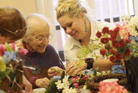 Marzena M'Barek of Chicago, director of the Oak Park Arms Adult Day Care, helps Esperanza Parrish of Oak Park